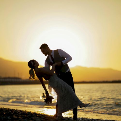 A couple dancing by the sea at sunset, romantically embracing with the sun low over the water.
